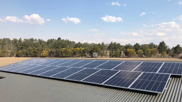 Solar panels on a roof with trees in the background