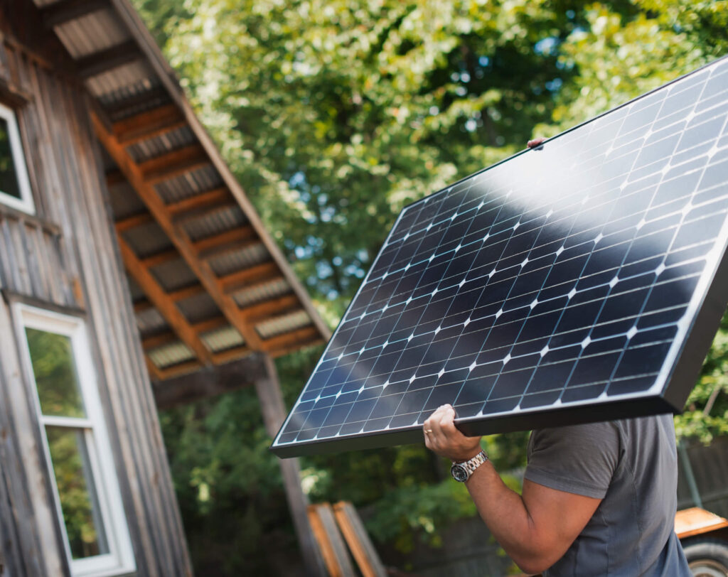 Work man lifting a solar panel into place