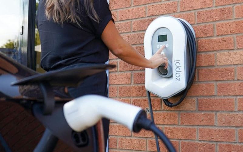 Woman using an electric vehicle charging point